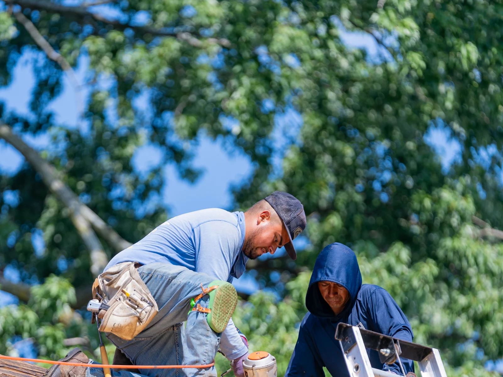 Rosales Roofing crew nailing down fresh roof decking at the eave in Evergreen Park, Illinois