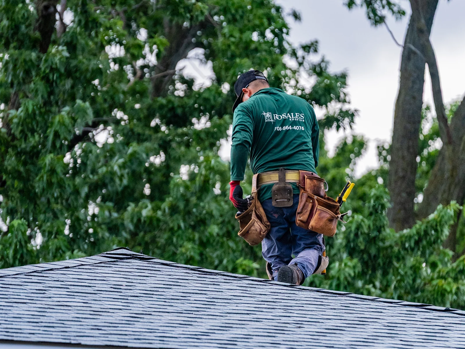 Rosales Roofing crew member walking the ridge of a newly shingled hip roof in Chicago Heights, Illinois